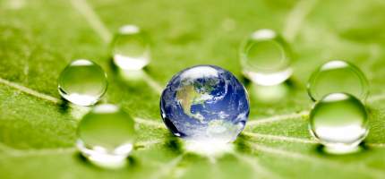 Die Erde in einem Wassertropfen auf einem grünen Blatt.