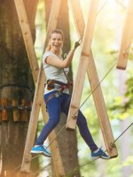 VRK Unfallversicherung – Junge Frau im Outdoor-Kletterpark.