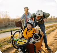 Eine junge Familie fährt zusammen mit Ihrem Hund Fahrrad.