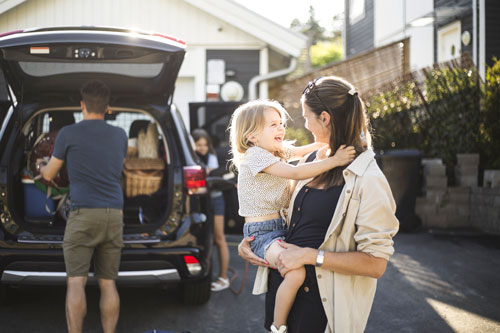 Eine Familie vor ihrem Auto